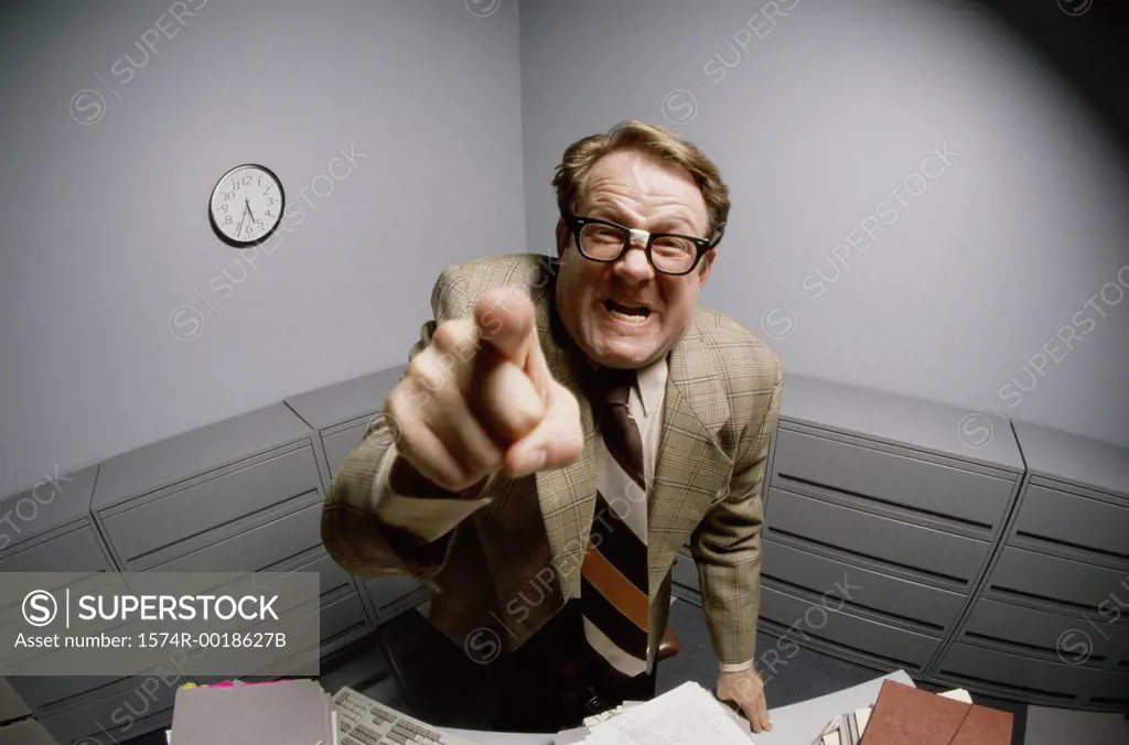 Portrait of a businessman pointing forward in anger