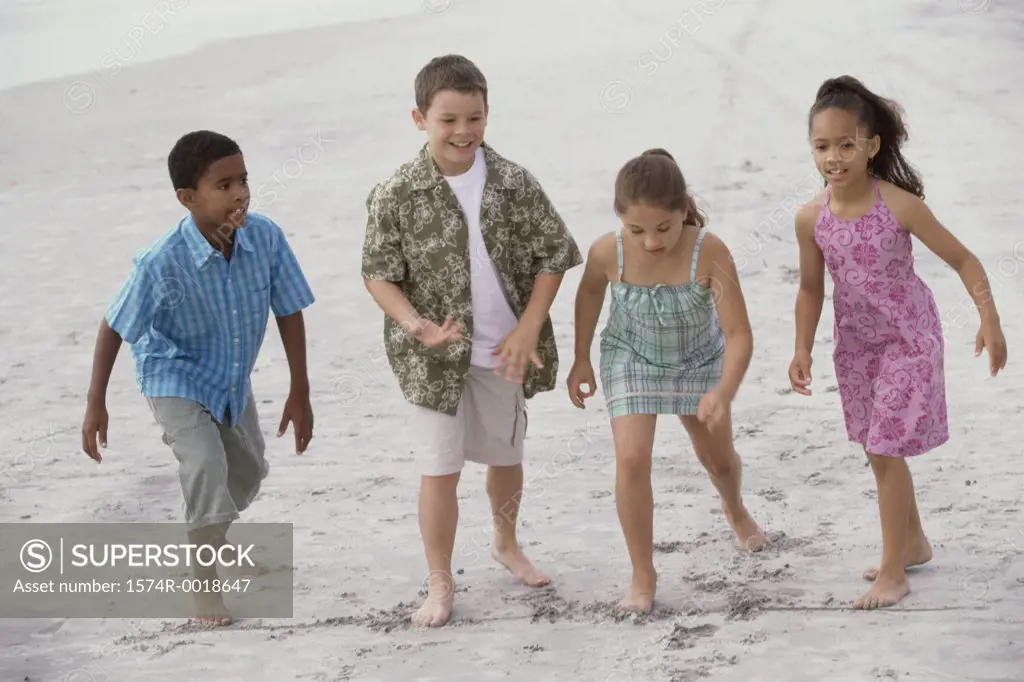 Two boys and two girls preparing for a race on the beach