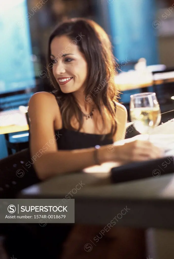 Young woman with a glass of white wine in front of her