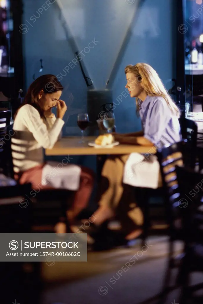 Two young women sitting together talking