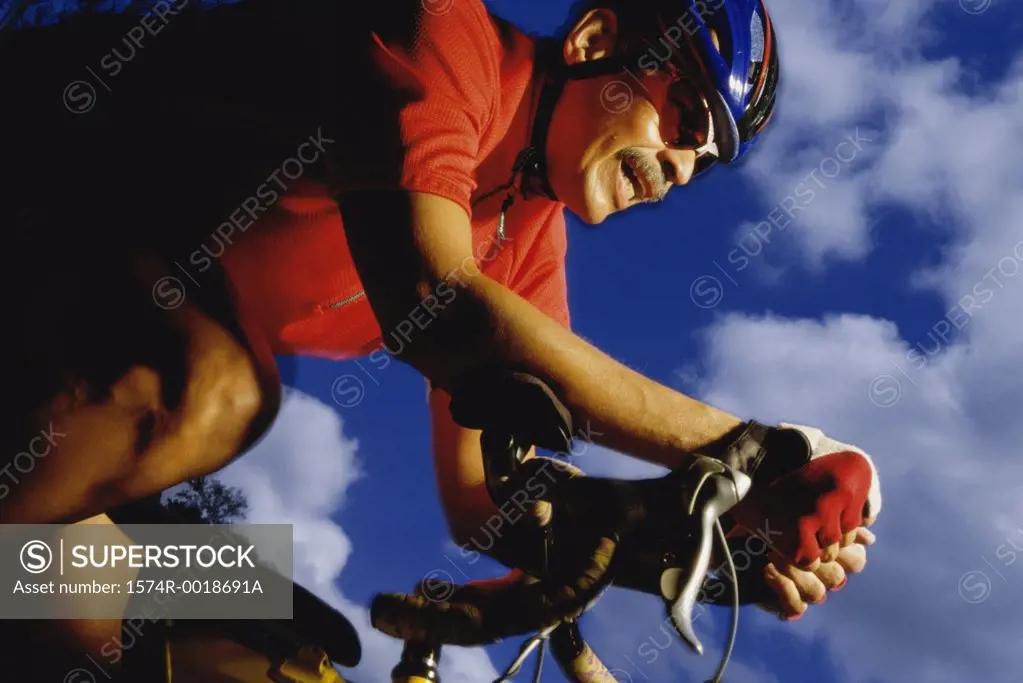 Low angle view of a mid adult man cycling