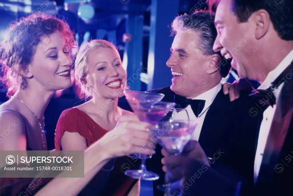 Close-up of two mature couples toasting with martini glasses