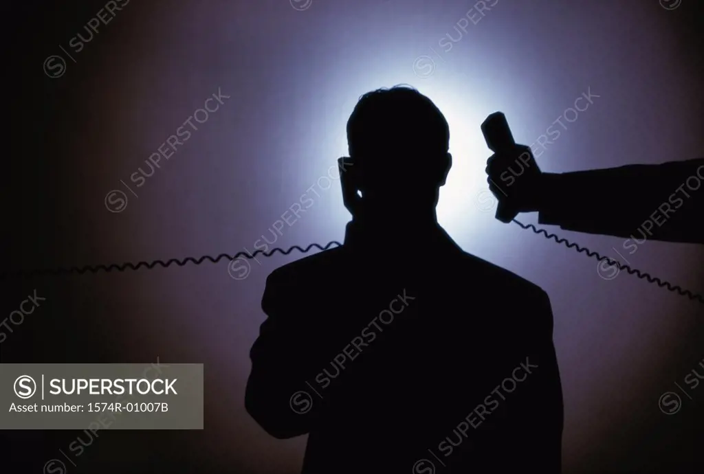 Silhouette of a businessman talking on a telephone