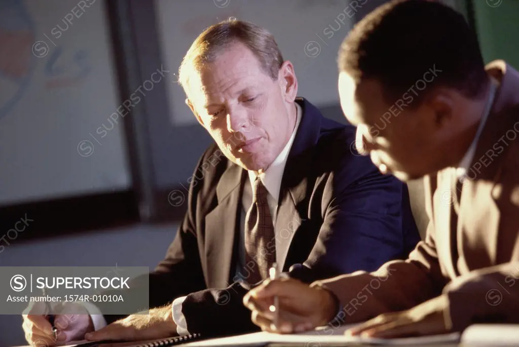 Two businessmen signing documents