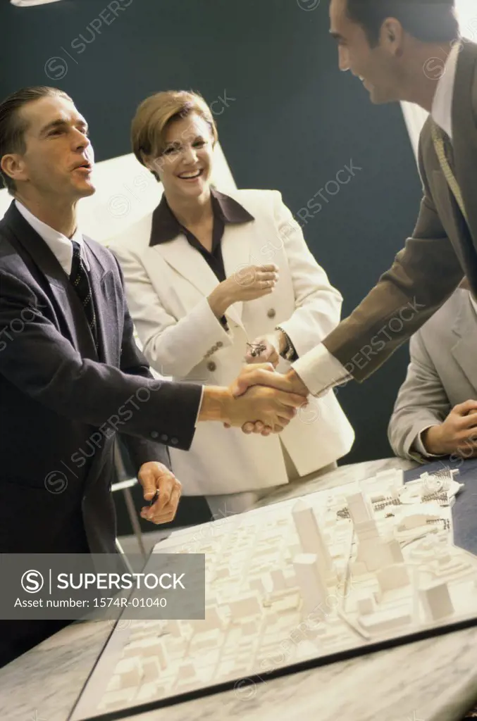 Business executives shaking hands at a presentation