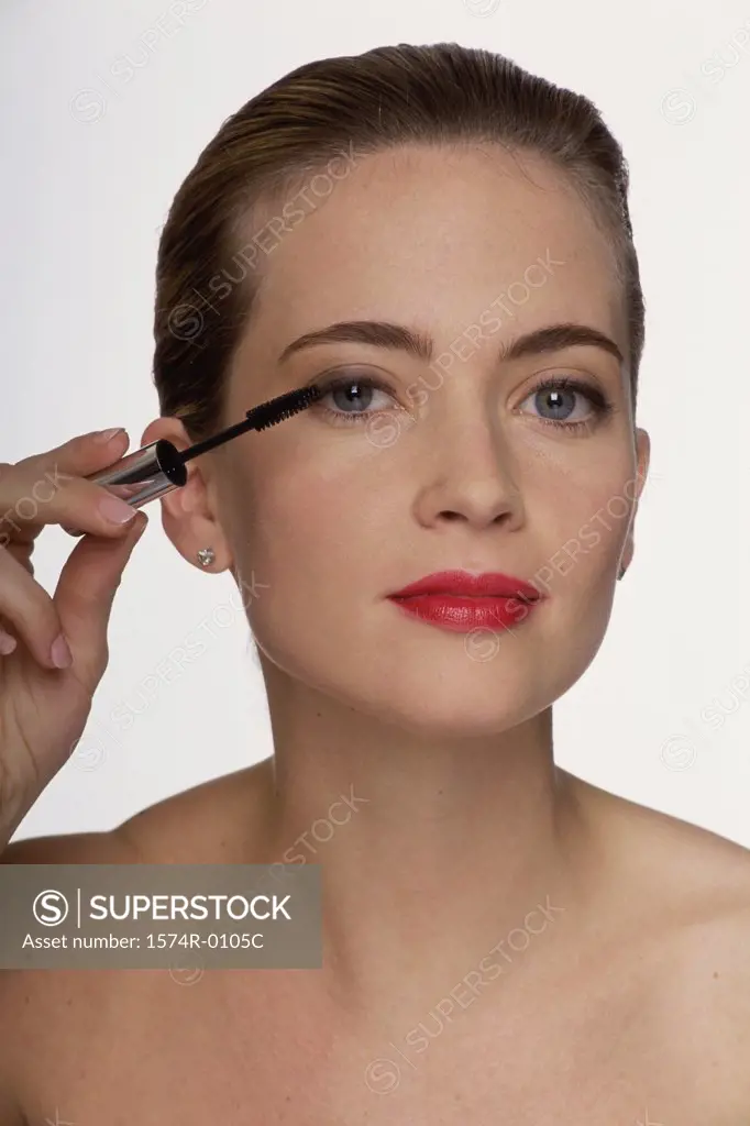 Close-up of a young woman applying mascara