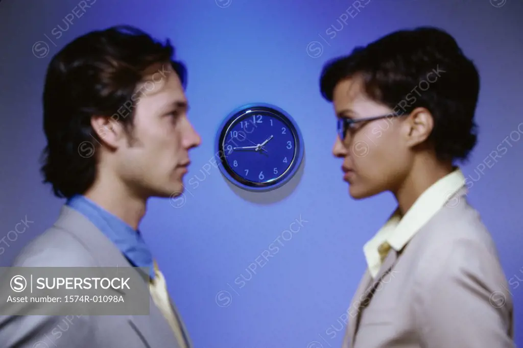 Side profile of businessman and a businesswoman looking at each other