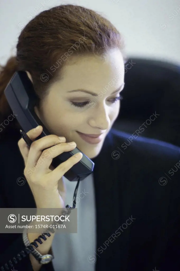 Close-up of a businesswoman talking on the landline telephone