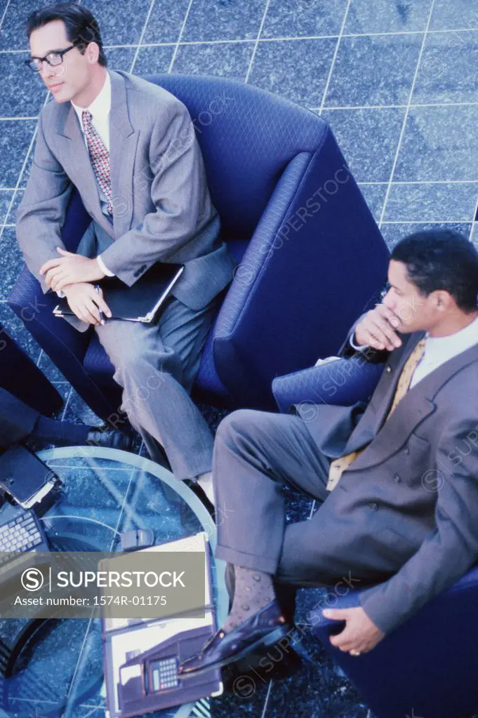 High angle view of two businessmen sitting on couches