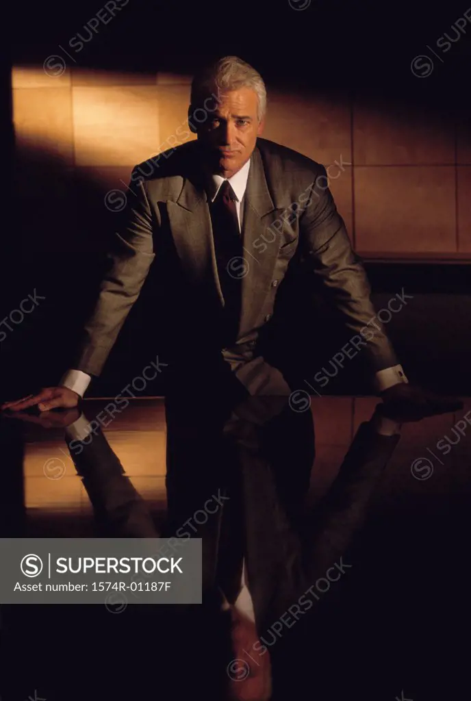 Portrait of a businessman leaning against a table