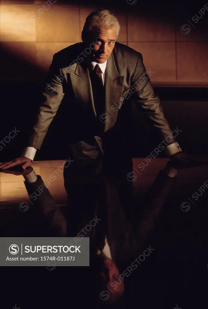 Portrait of a businessman leaning against a table