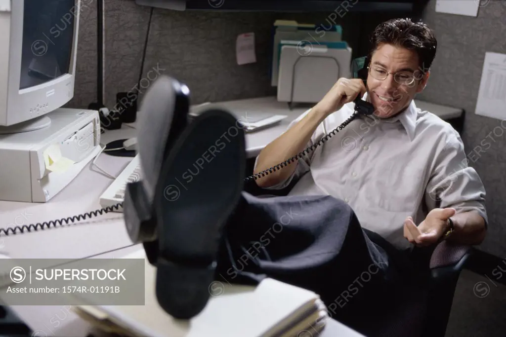 Businessman talking on a landline telephone on the desk