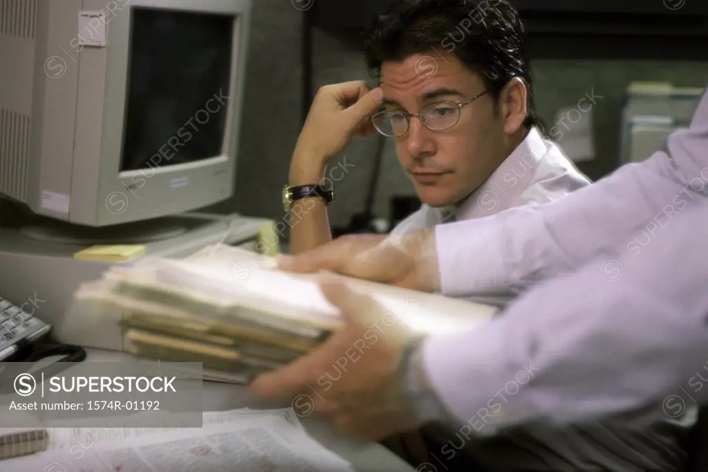 Businessman looking at a pile of papers in a person's hands