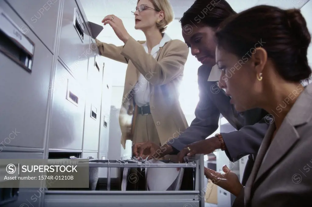 Three businesswomen at a filing cabinet