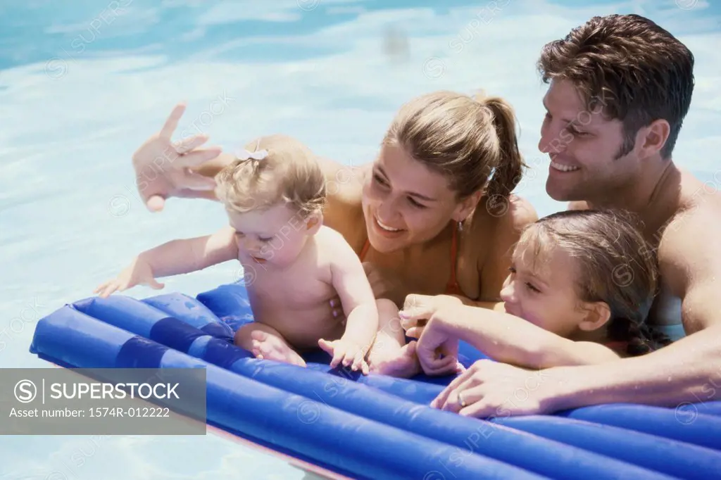 Parents and their two daughters in a swimming pool