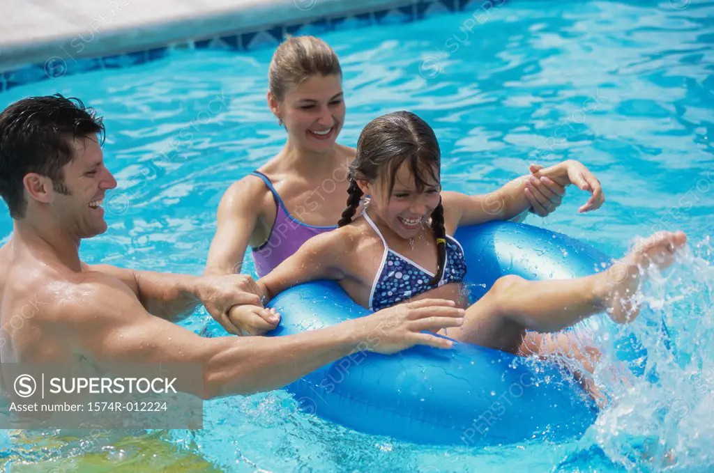 Parents and their daughter playing in a swimming pool