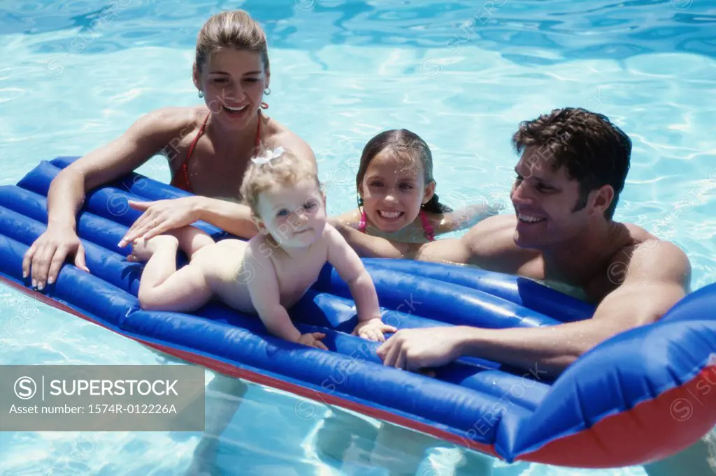 Parents and their two daughters in a swimming pool