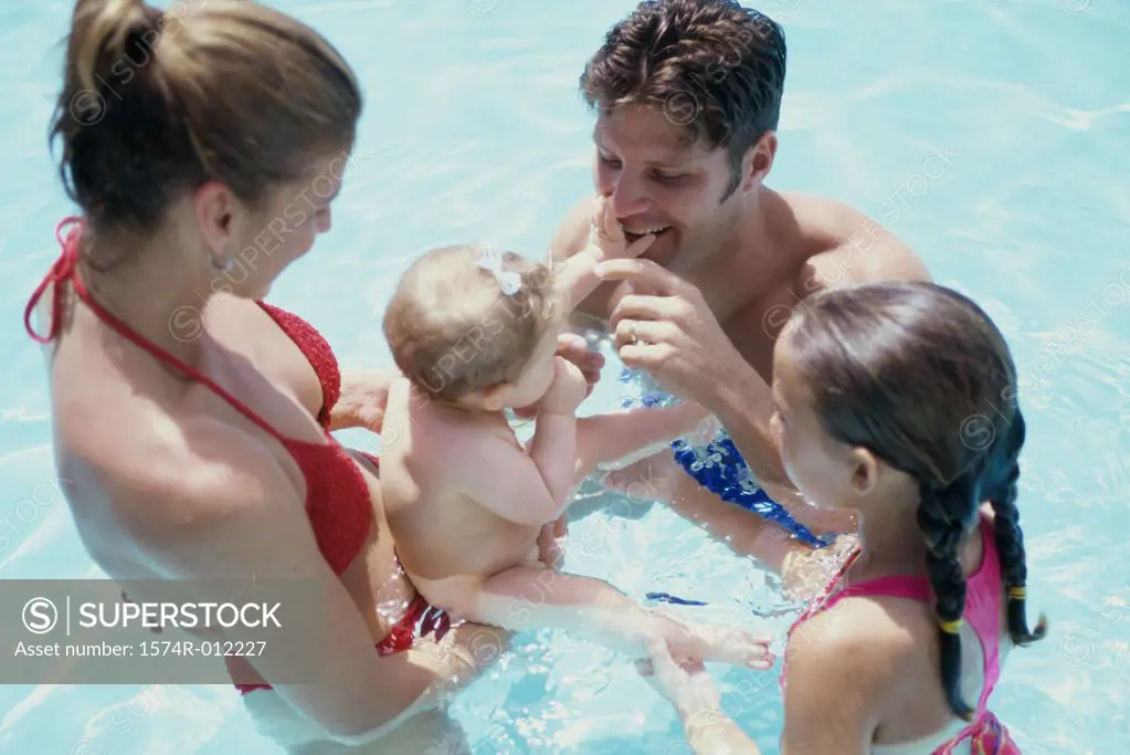 High angle view of parents and their two daughters in a swimming pool