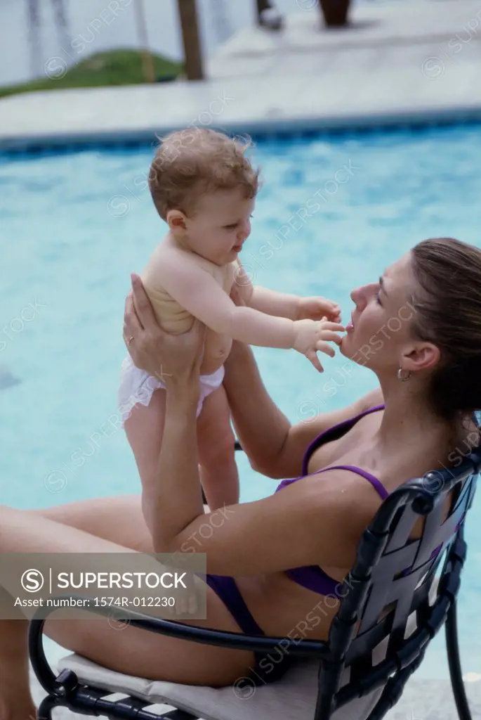 High angle view of a mother playing with her son at poolside