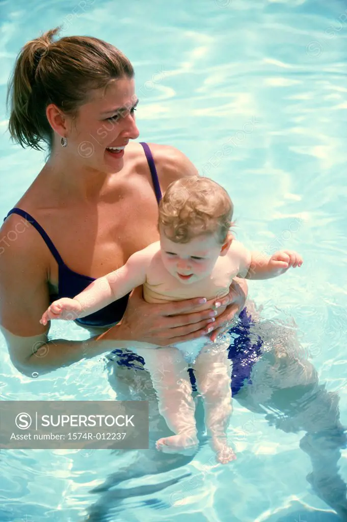 High angle view of a mother and her son swimming in a swimming pool