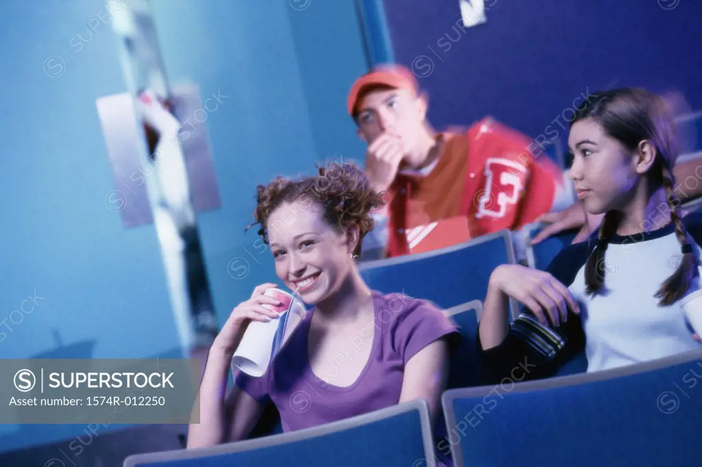 Two teenage girls watching a movie in a theater