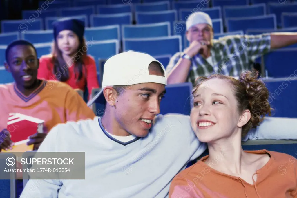 Close-up of a teenage couple sitting in a movie theater