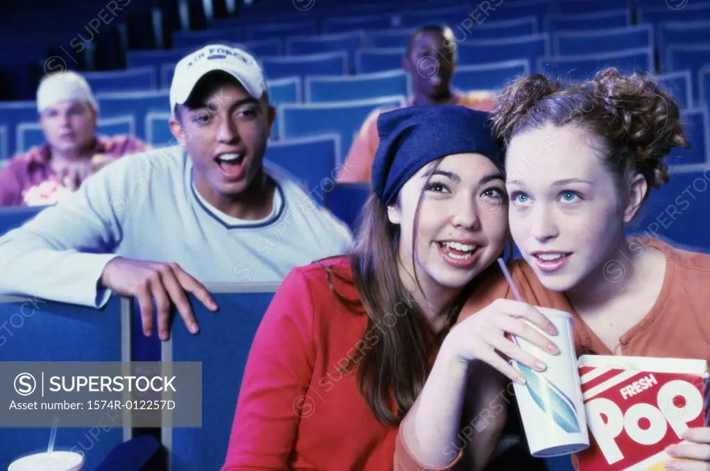 Close-up of two teenage girls sitting in a movie theater