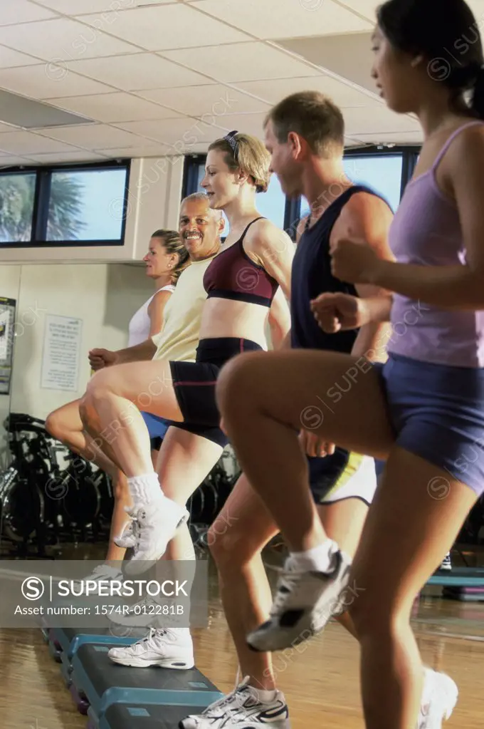 Side profile of a group of people exercising in a step aerobics class