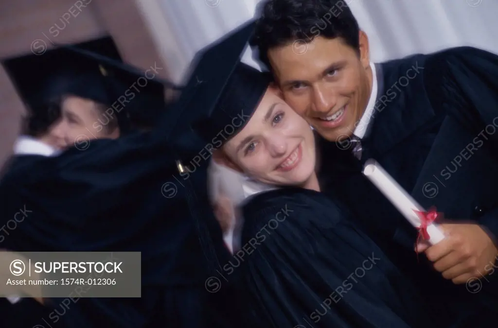 Young graduate couple holding a diploma and smiling