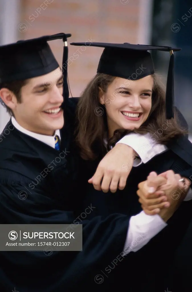 Close-up of a young graduate couple smiling