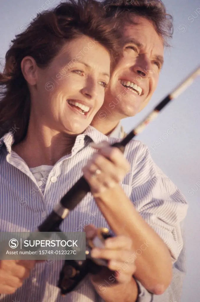 Close-up of a mid adult couple fishing together