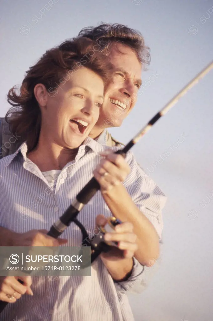 Close-up of a mid adult couple fishing together