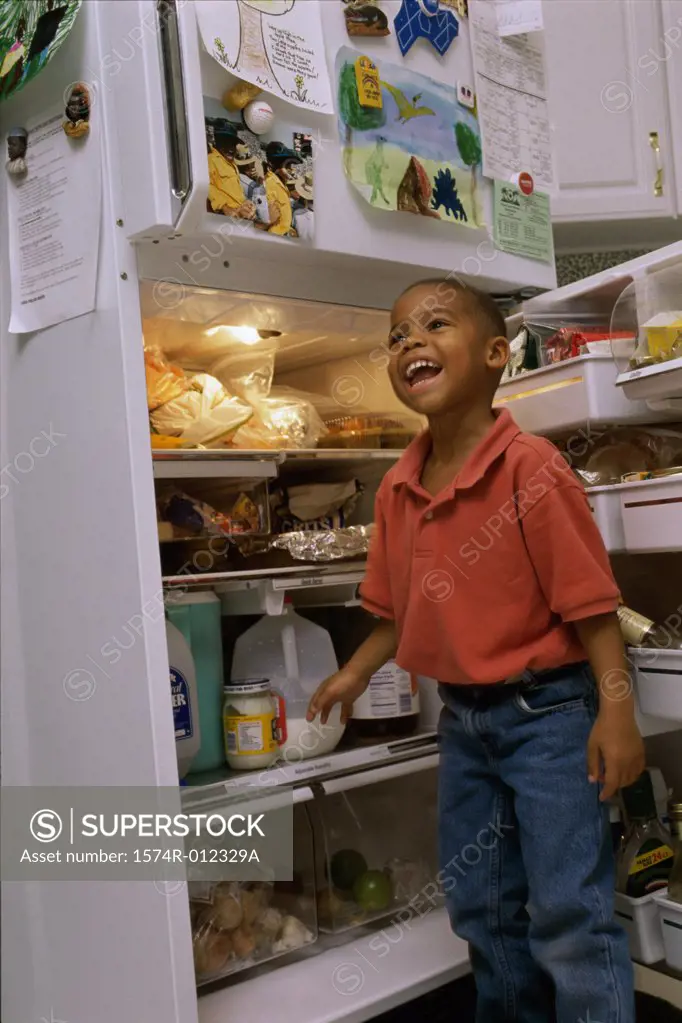 Boy standing in front of an open refrigerator