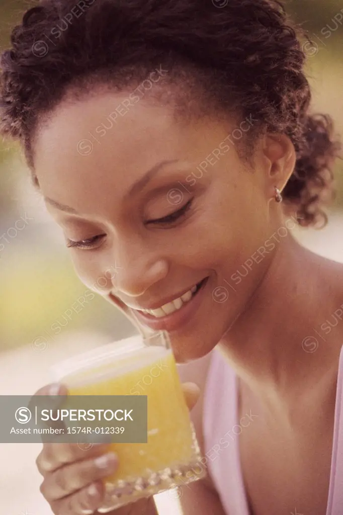 Close-up of a young woman drinking a glass of juice