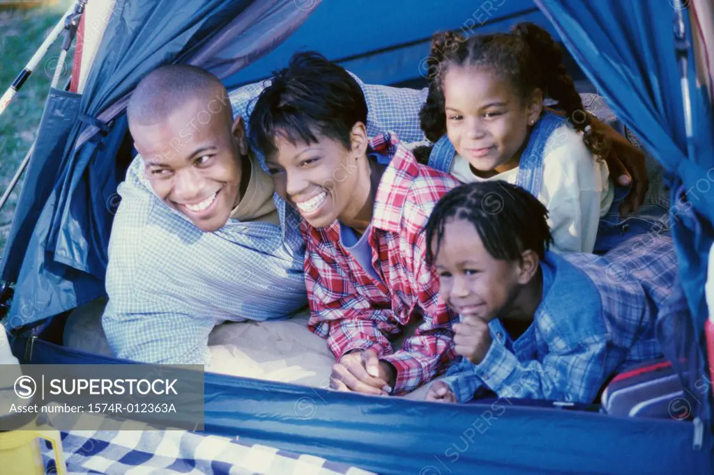 Parents with their children smiling in a tent