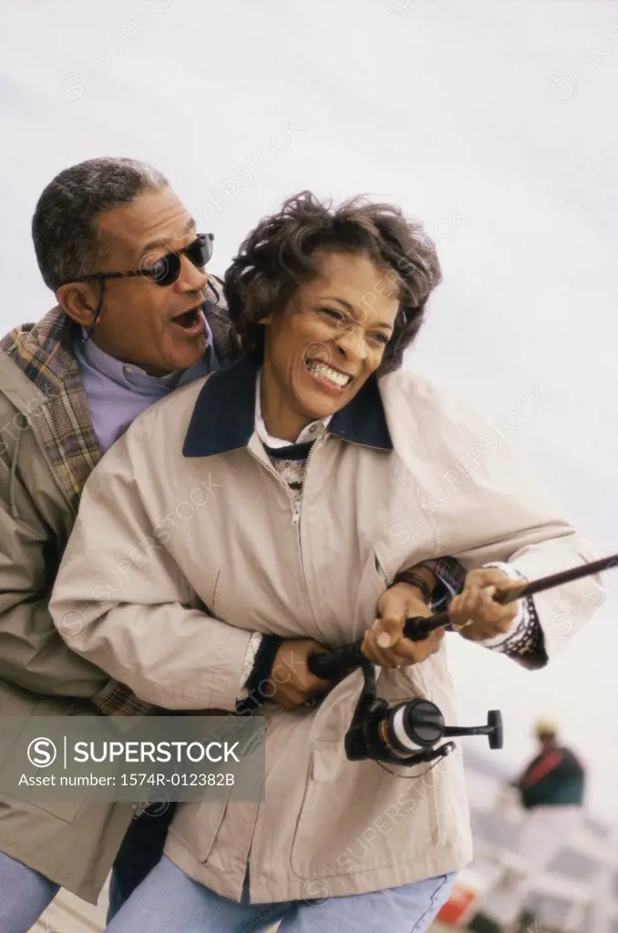 Close-up of a mature couple holding a fishing rod