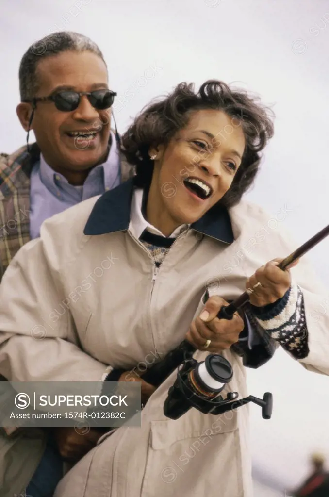 Close-up of a mature couple holding a fishing rod