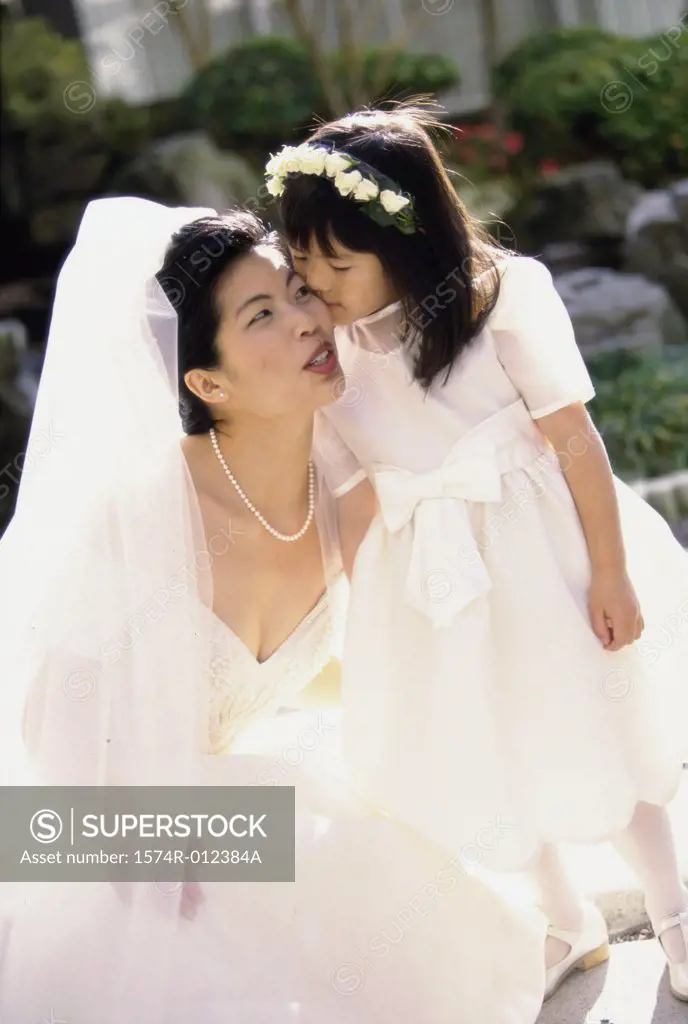 High angle view of a flower girl kissing a bride's cheek