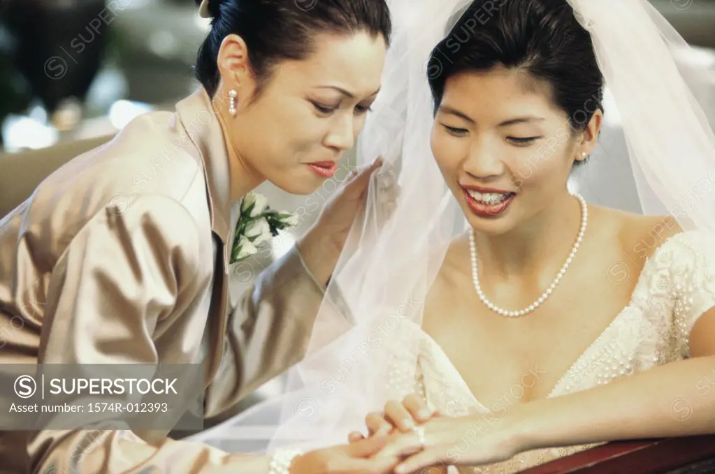 Close-up of a bride showing her wedding ring to her mother