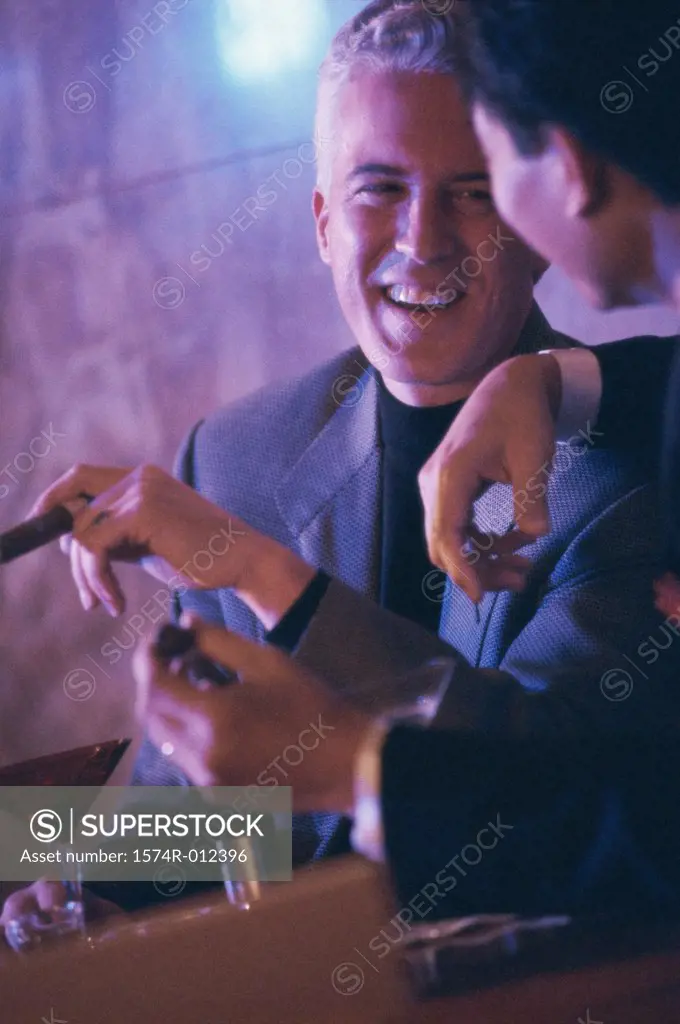 Close-up of two mid adult men talking in a bar