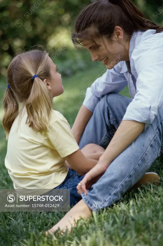 Side profile of a mother and daughter sitting in a park