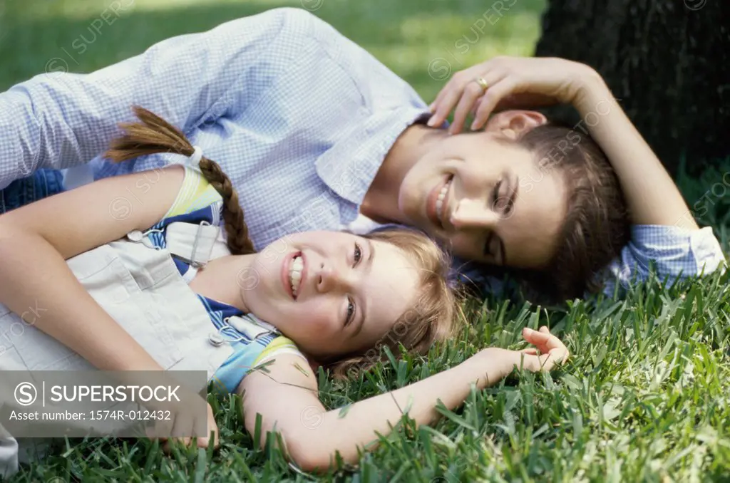 Close-up of a mother and daughter lying in the grass in a park