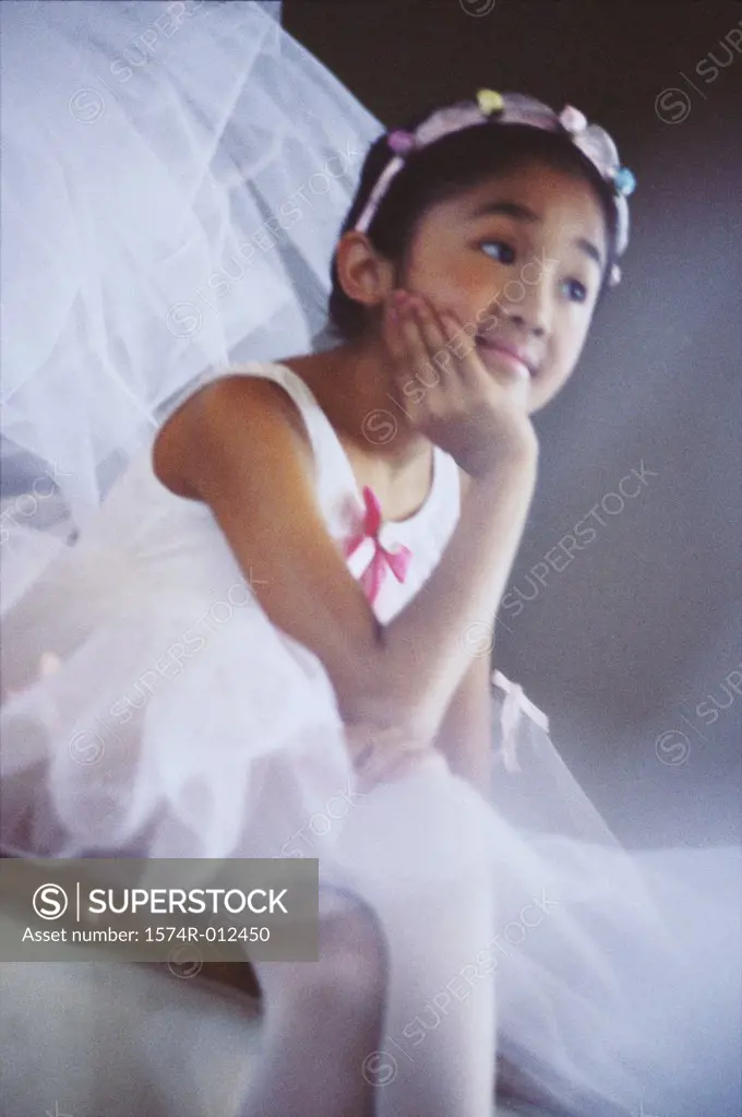 Close-up of a ballerina sitting with her hand on her chin