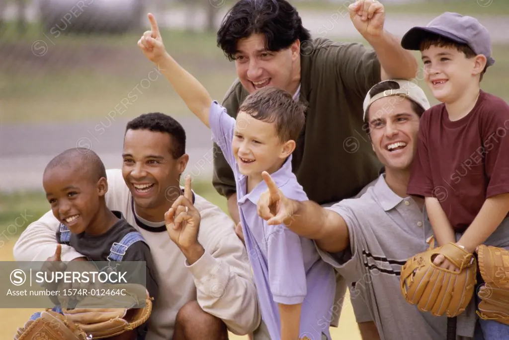 Close-up of three fathers with their sons wearing baseball gloves in a baseball field