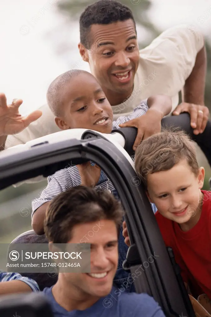 Close-up of two fathers with their sons in a jeep