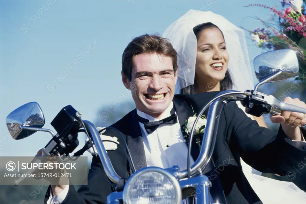 Close-up of a newlywed couple riding a motorcycle