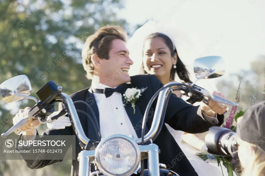Low angle view of a newlywed couple riding a motorcycle