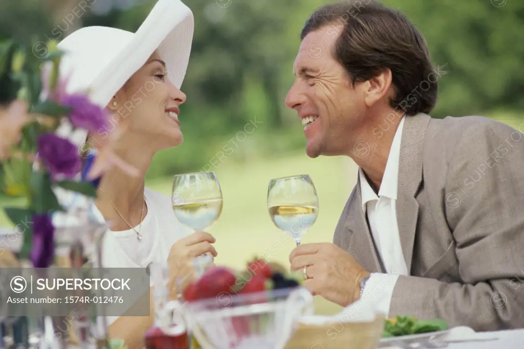 Side profile of a mature couple holding wineglasses