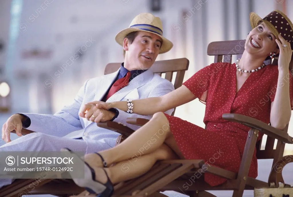Young couple sitting in deck chairs on a cruise ship
