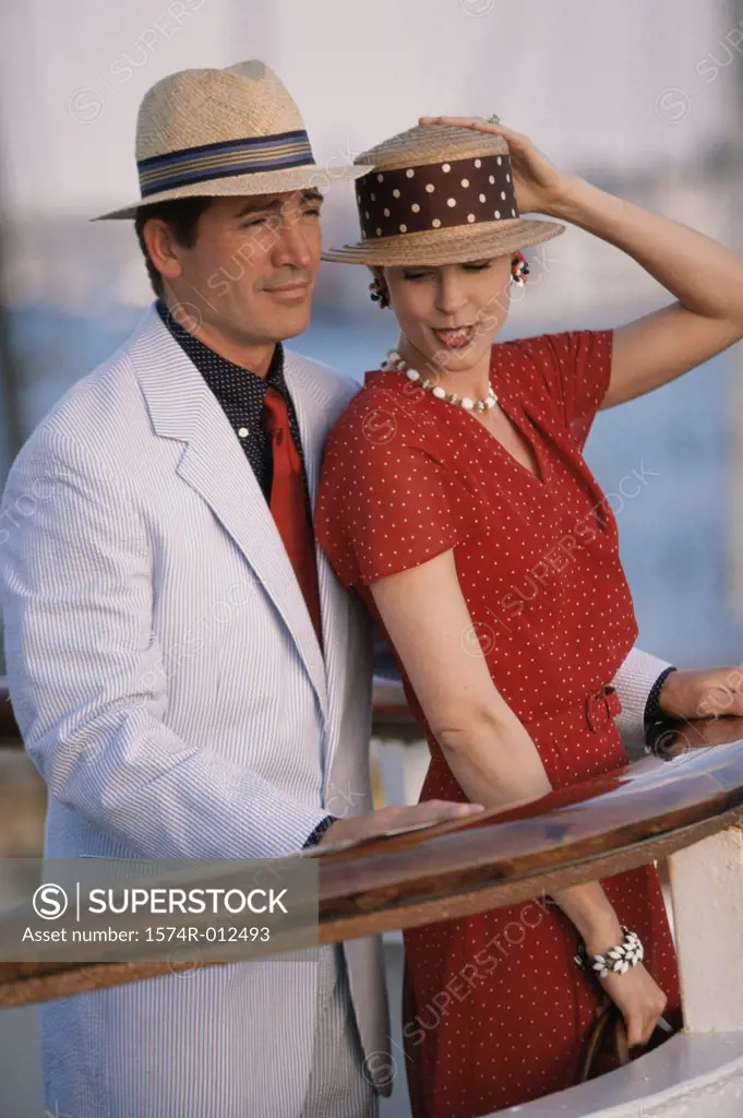 Side profile of a young couple standing on the deck of a cruise ship